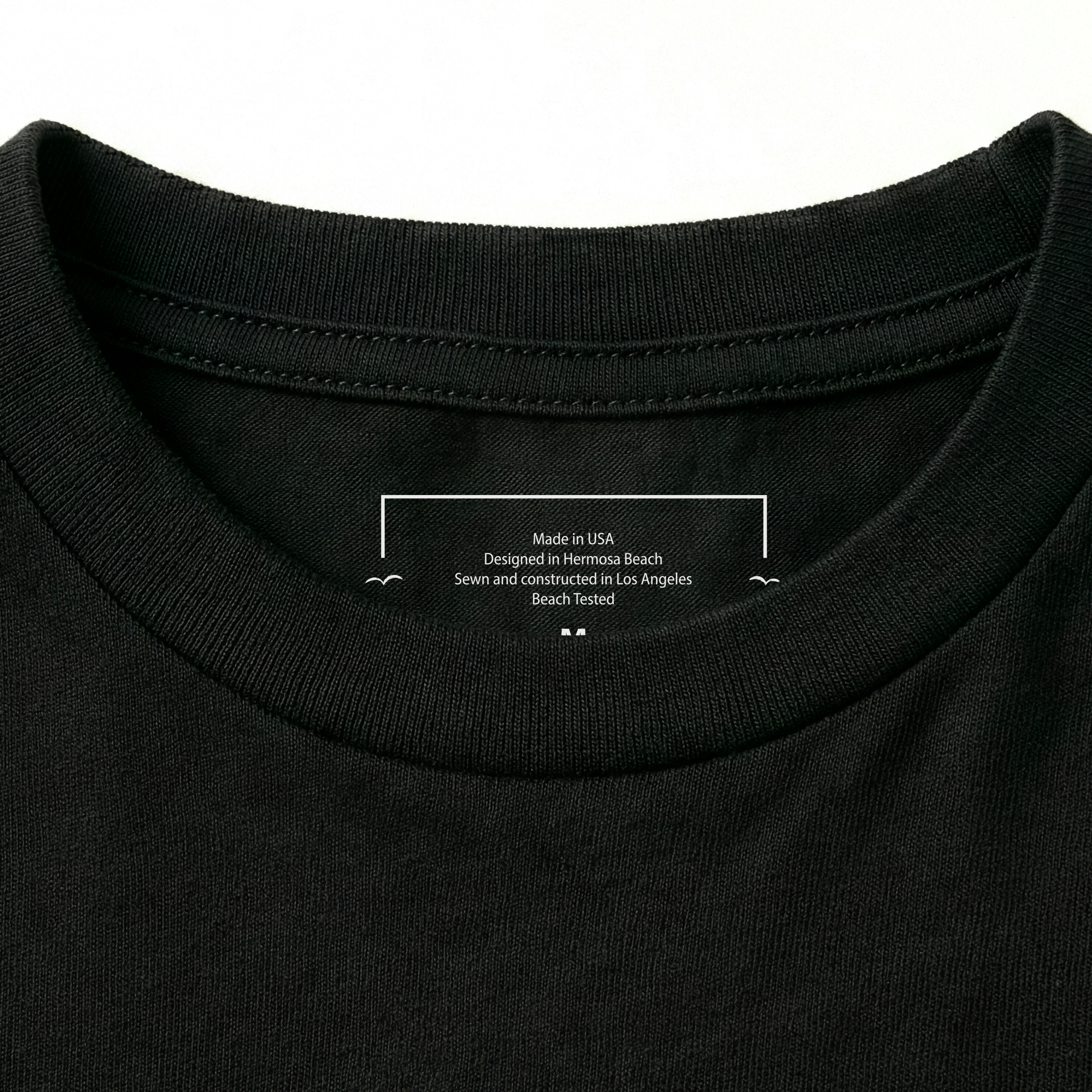 Close-up of a black t-shirt collar with text on a white background