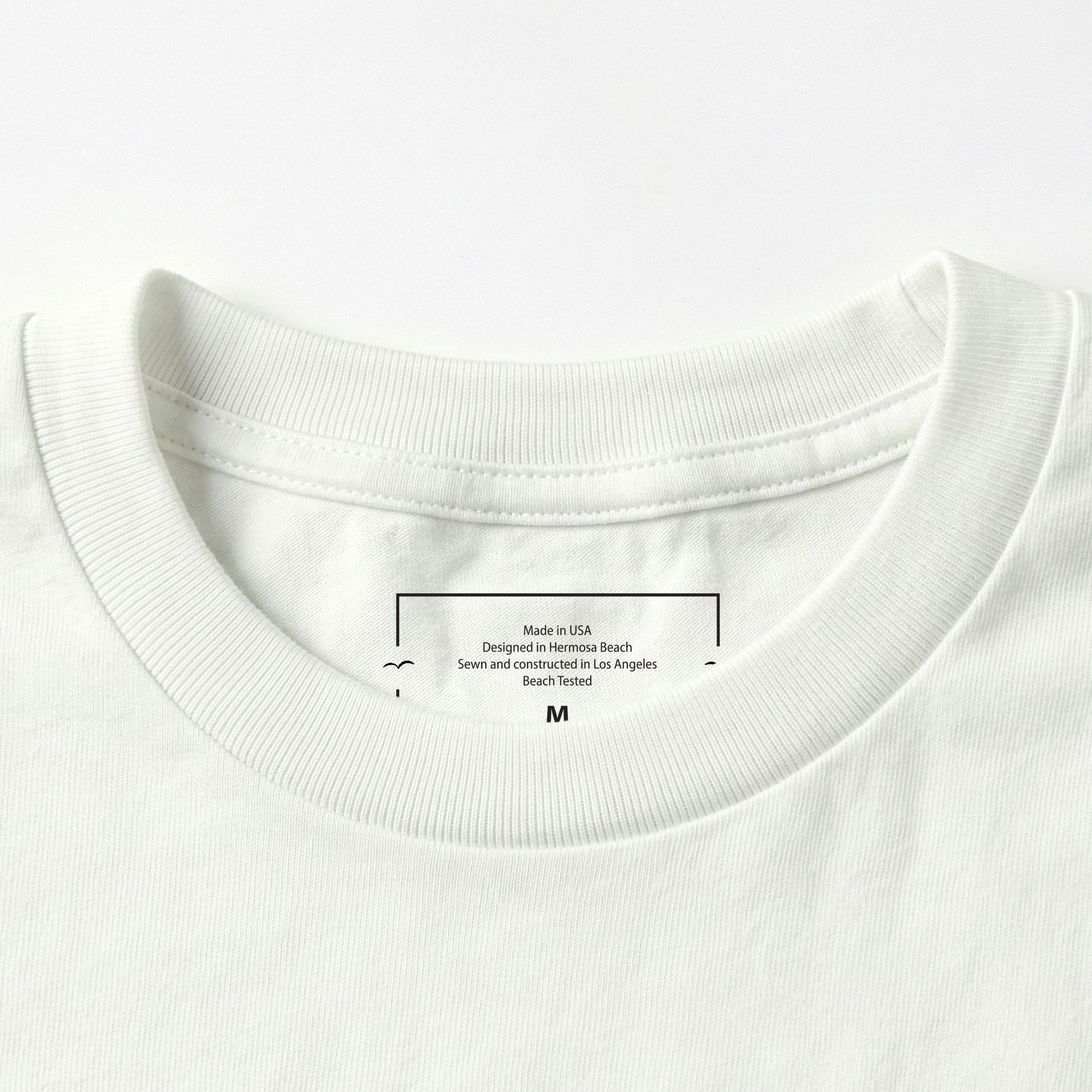 Close-up of a white t-shirt collar with a label on a white background