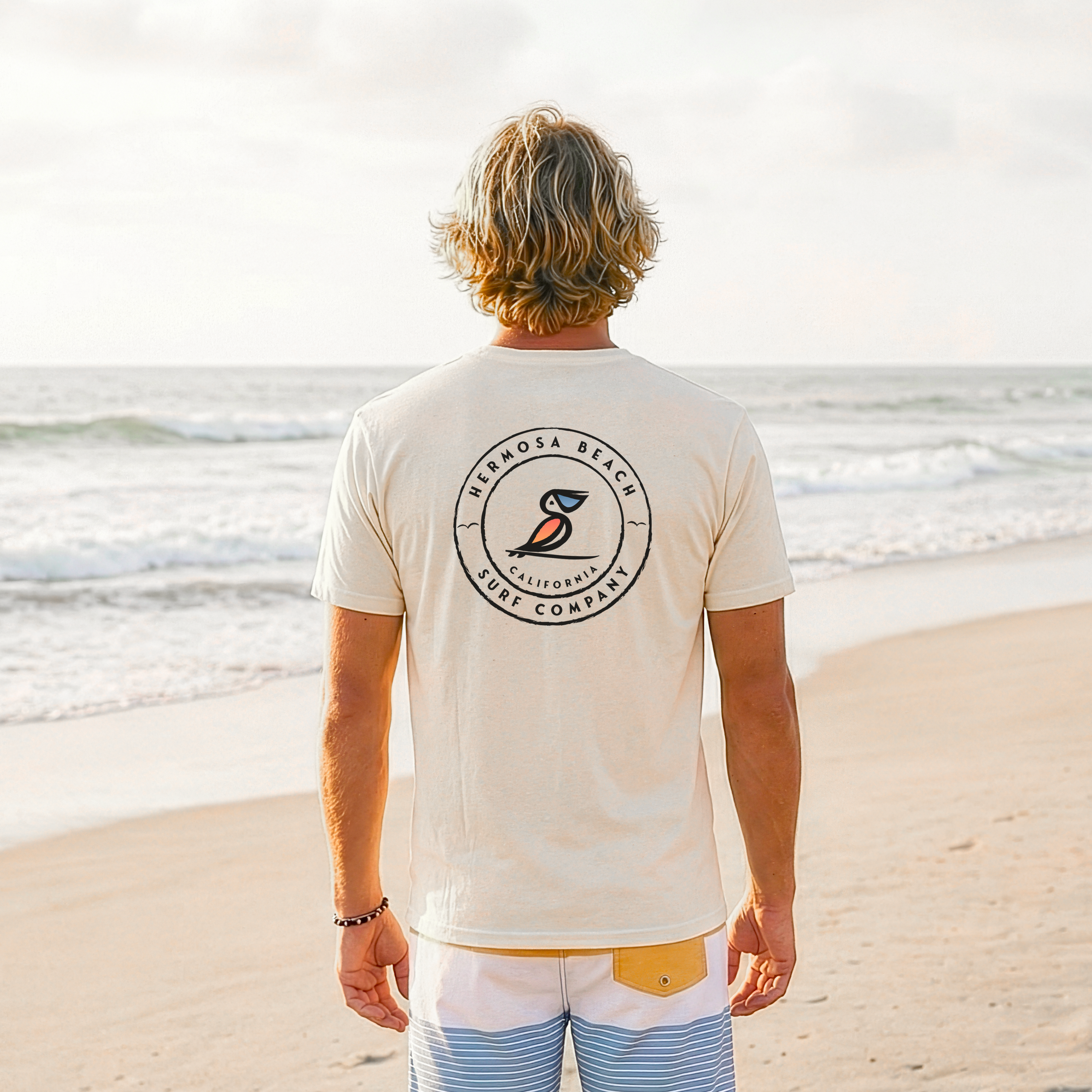Person wearing a t-shirt with a logo on the beach