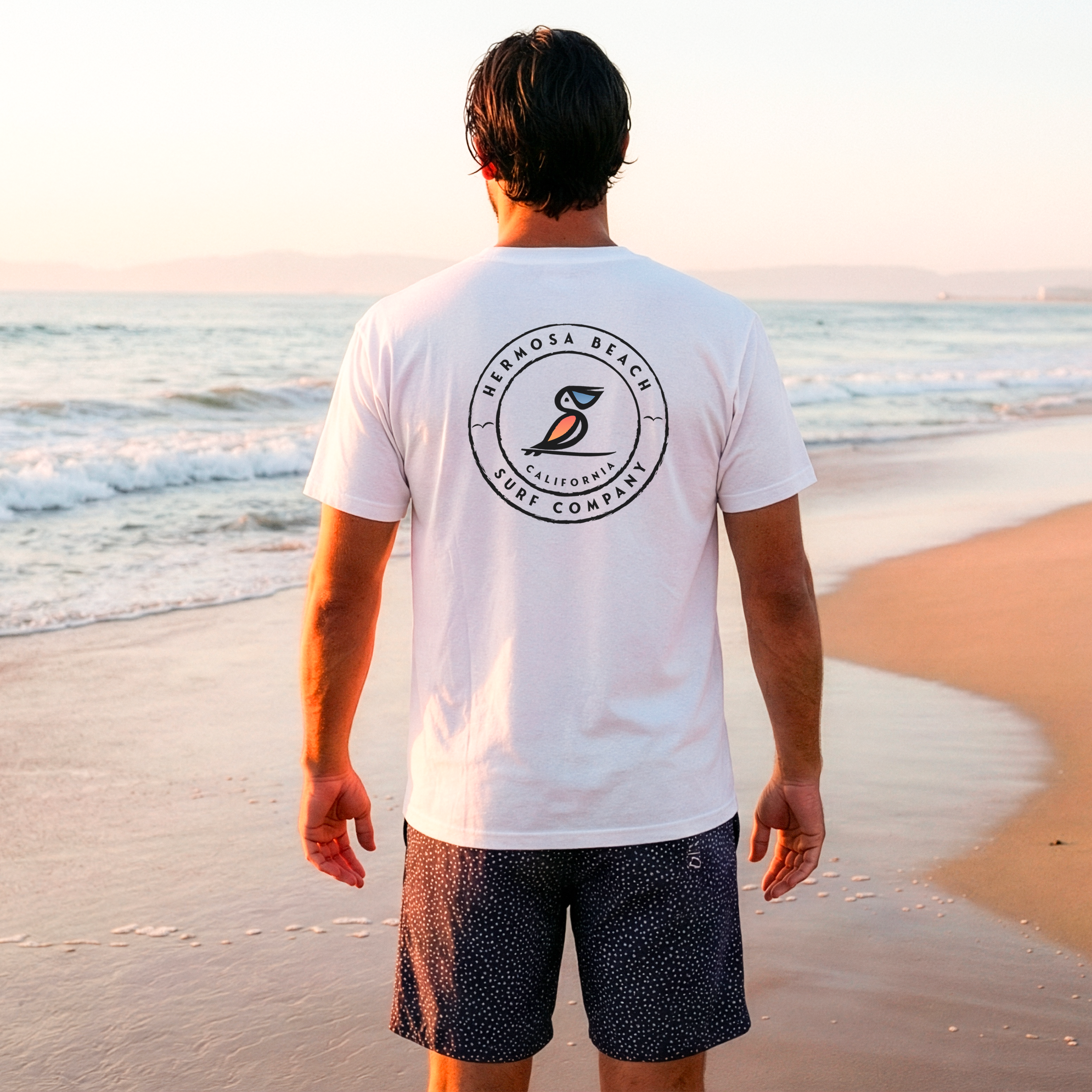 Man wearing a white t-shirt with a logo on the beach