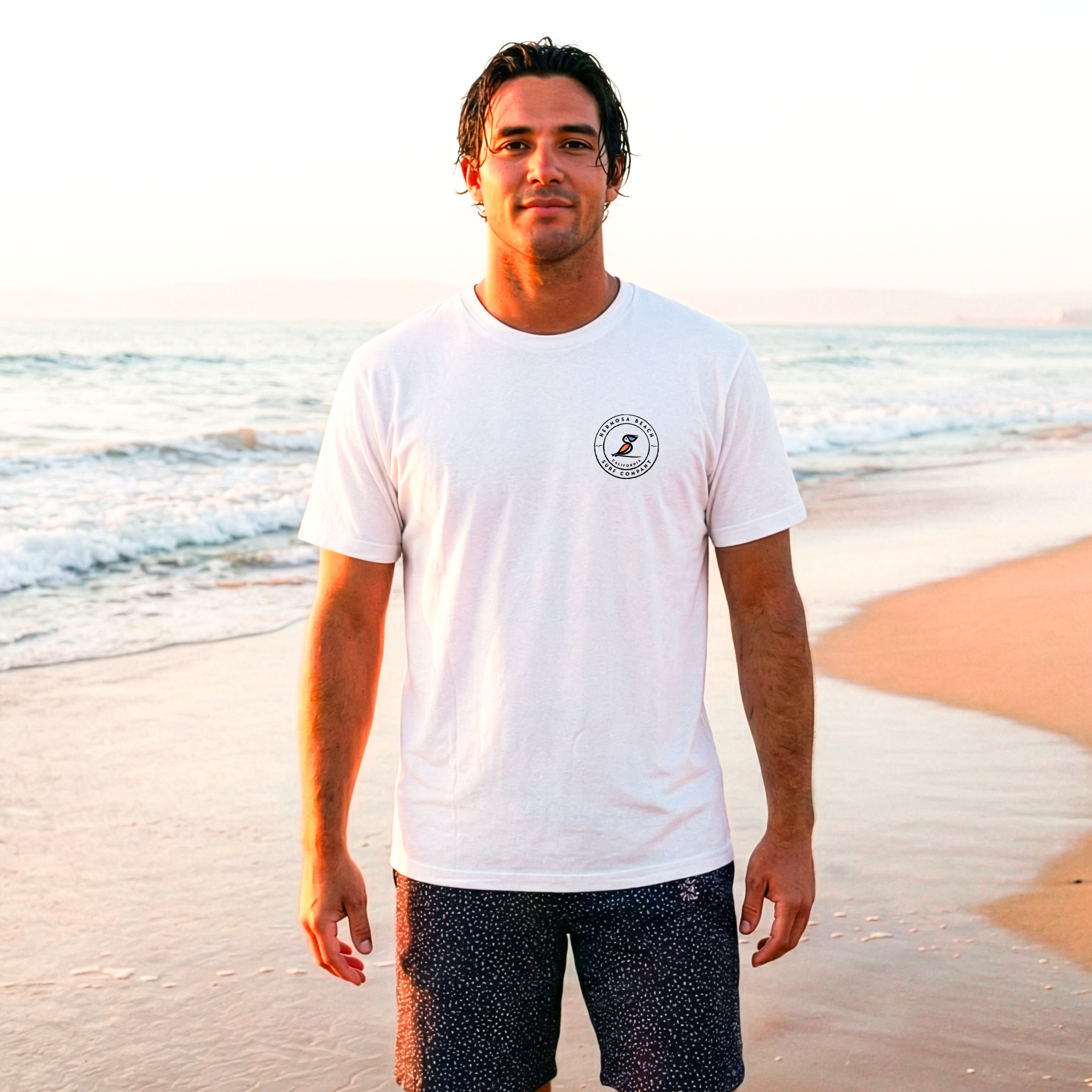 Man wearing a white t-shirt with a logo on a beach