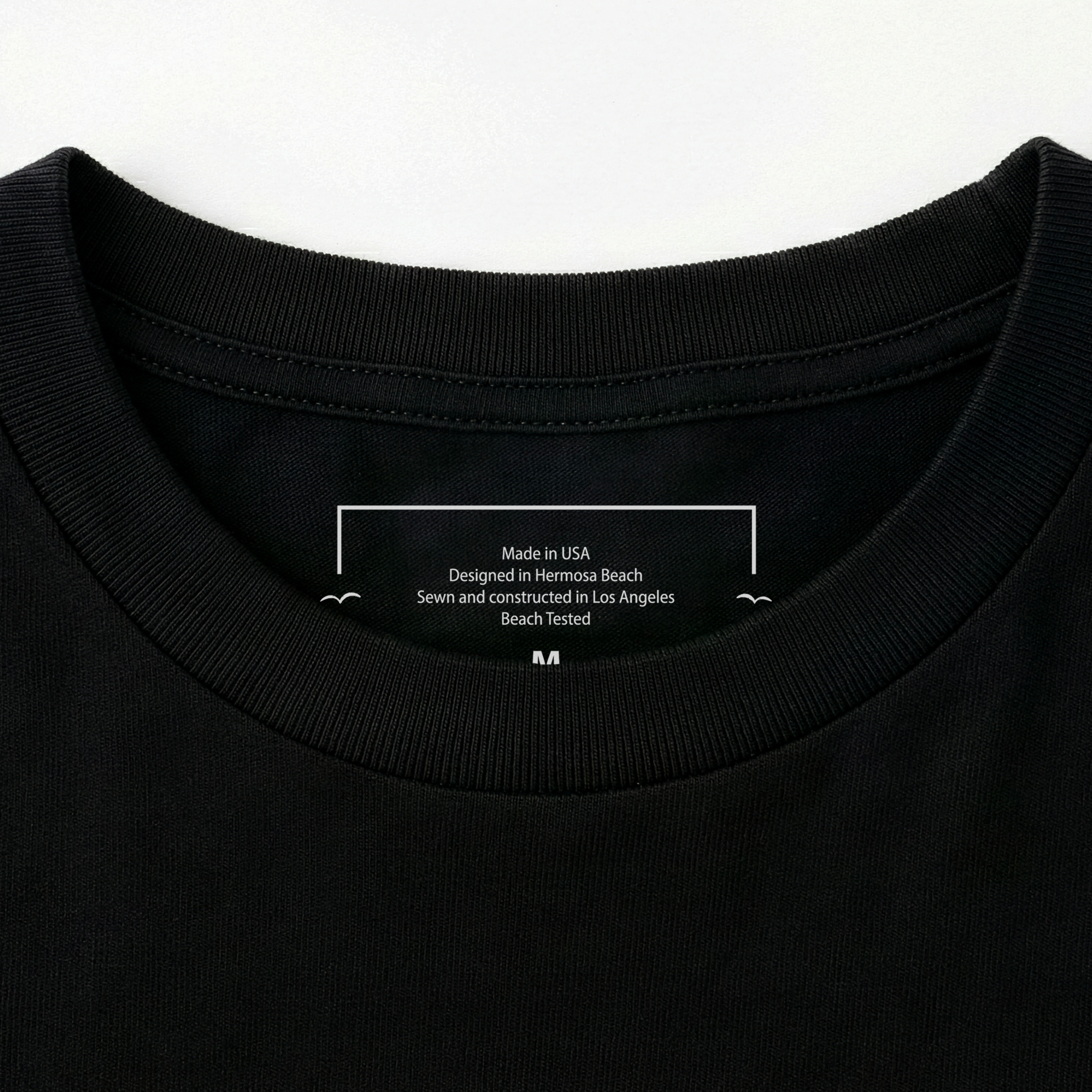 Close-up of a black t-shirt with a label on the collar.
