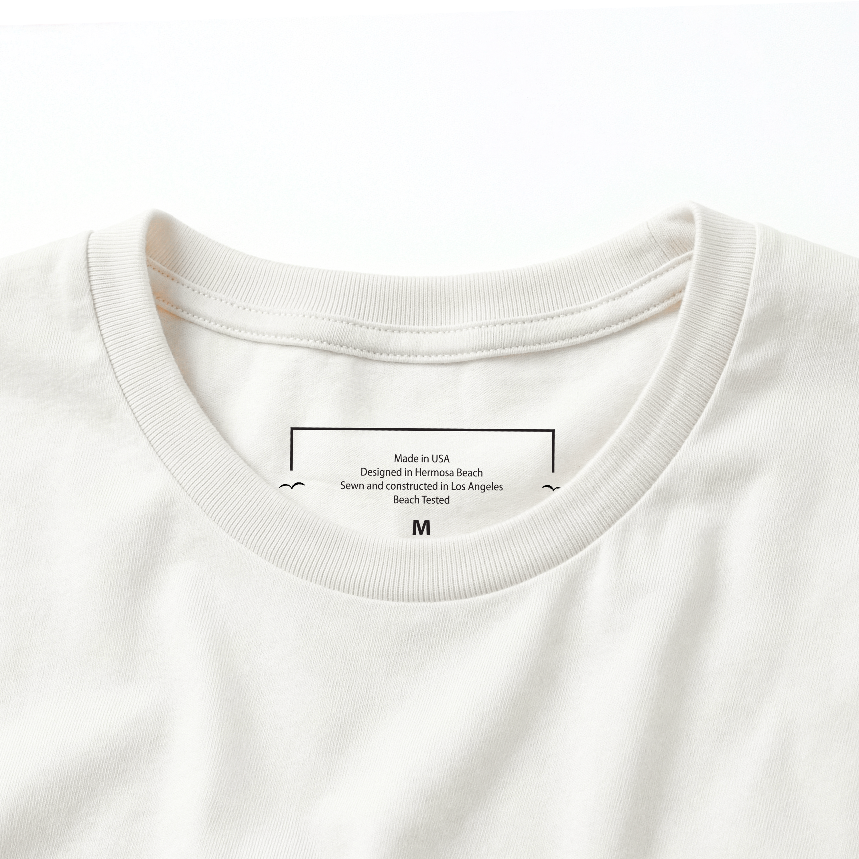 Close-up of a cream t-shirt with text on the collar area.