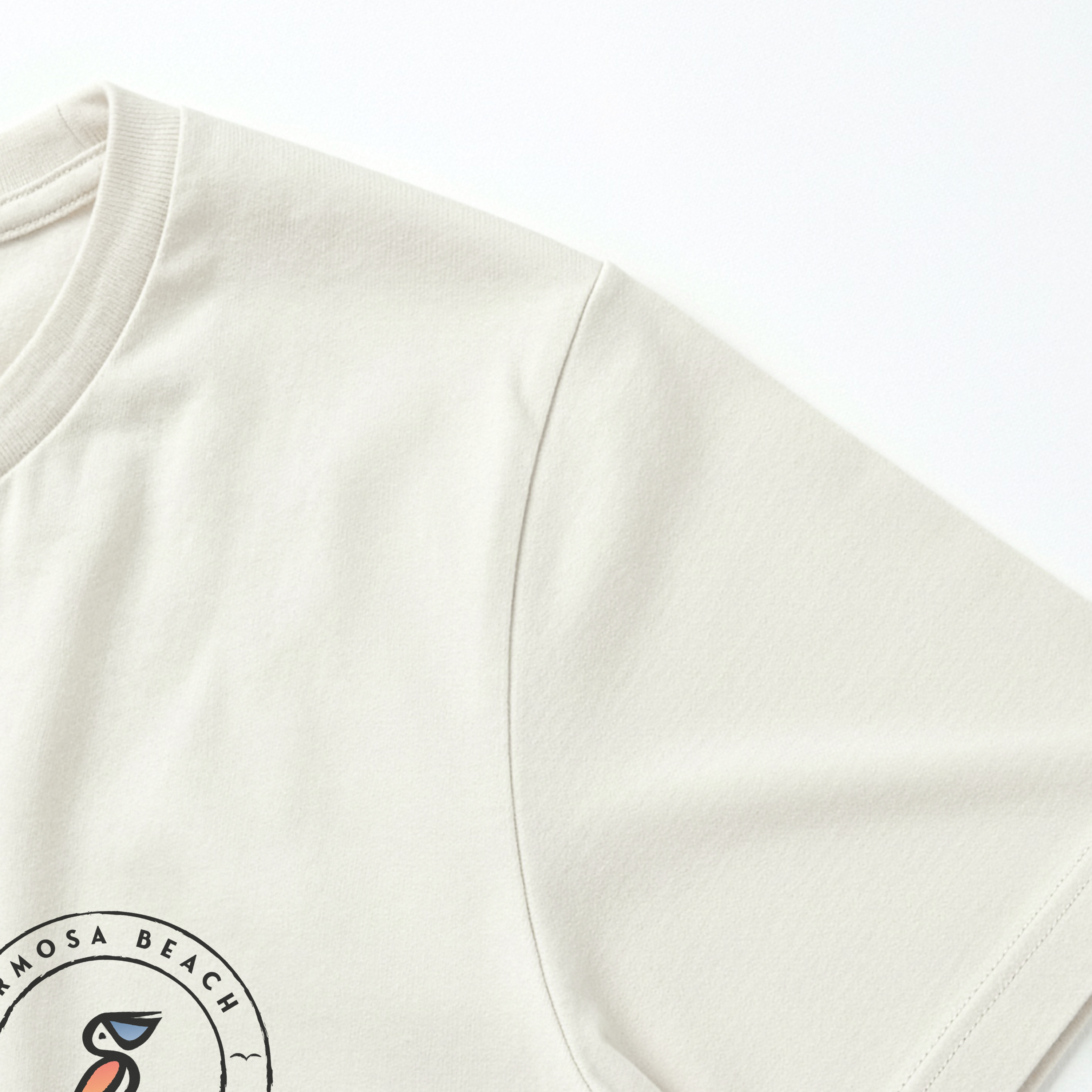 Close-up of a cream sweatshirt with a logo on the sleeve against a white background