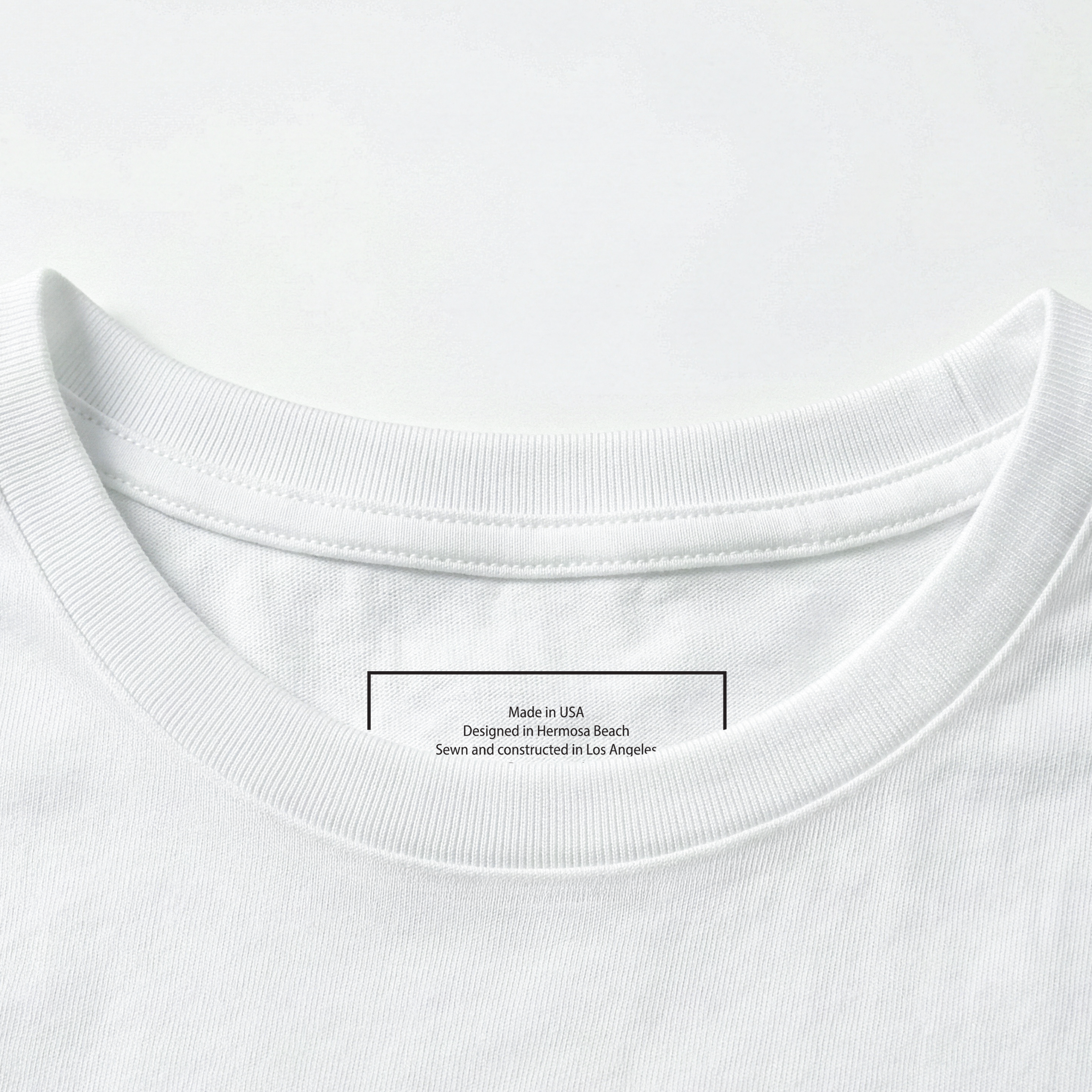 Close-up of a white t-shirt collar with a label on a white background