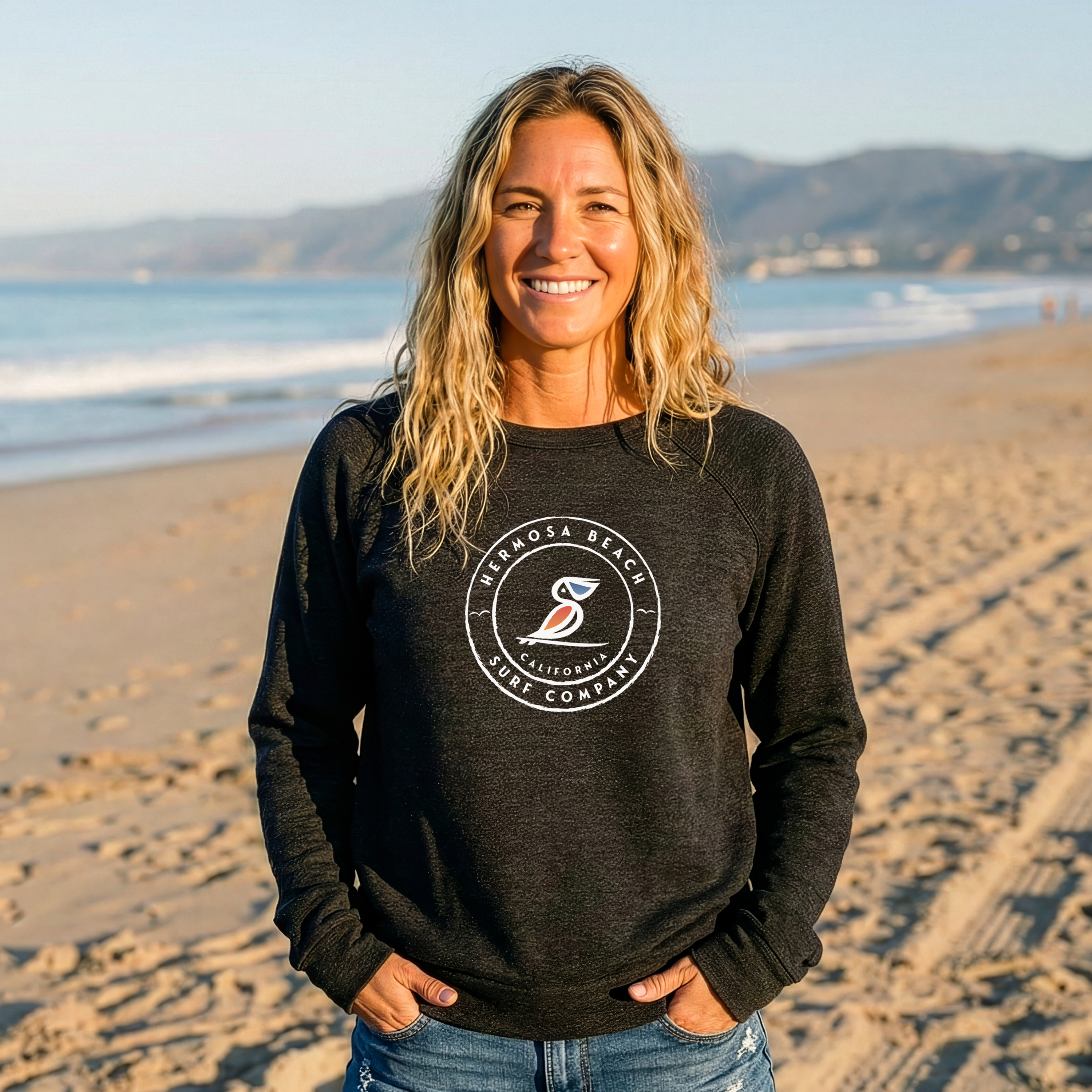 Woman wearing a Grey sweatshirt with a logo on a beach