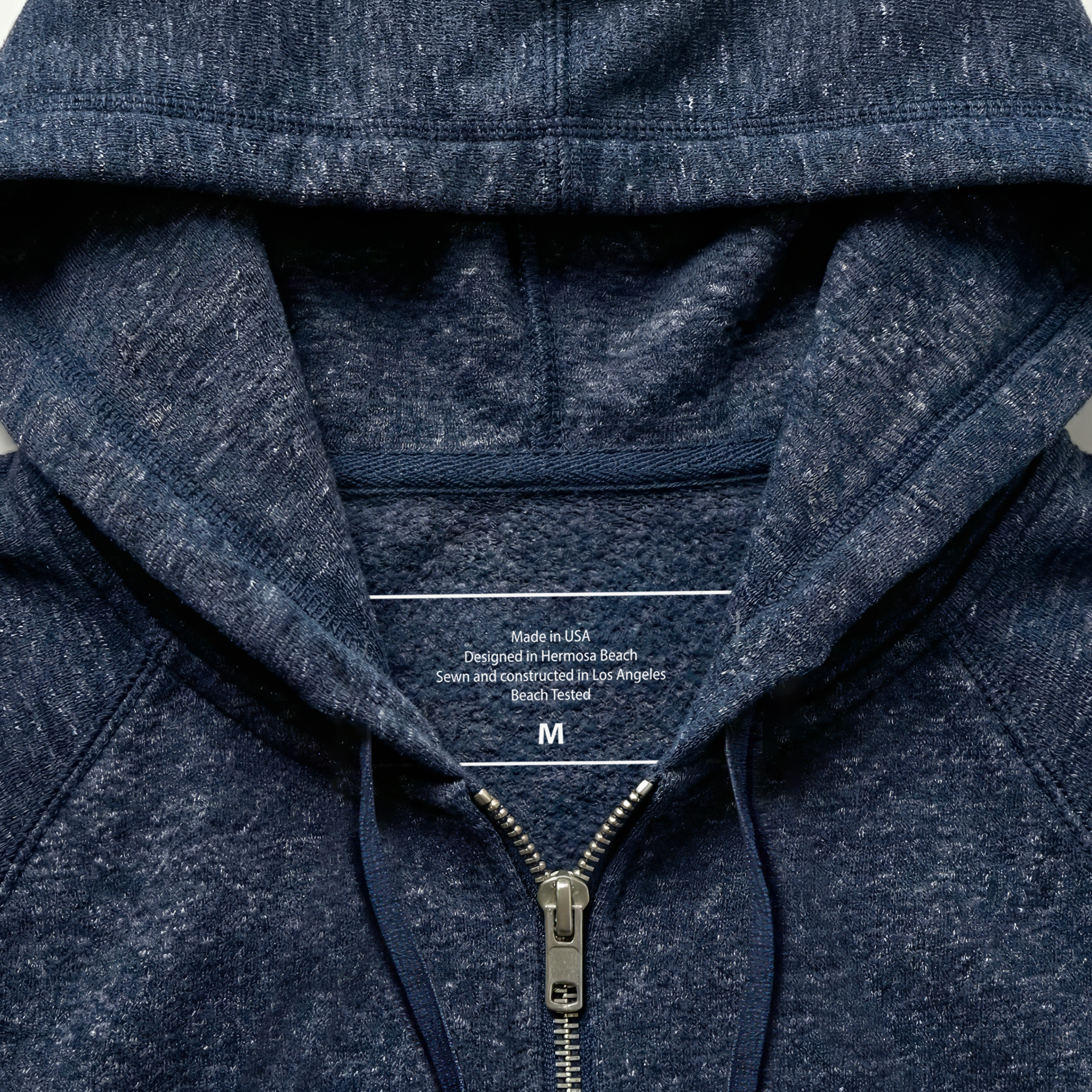 Close-up of a navy blue hoodie with text on the inside of the hood.