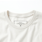Close-up of a cream t-shirt with text on the collar area.