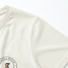 Close-up of a cream sweatshirt with a logo on the sleeve against a white background