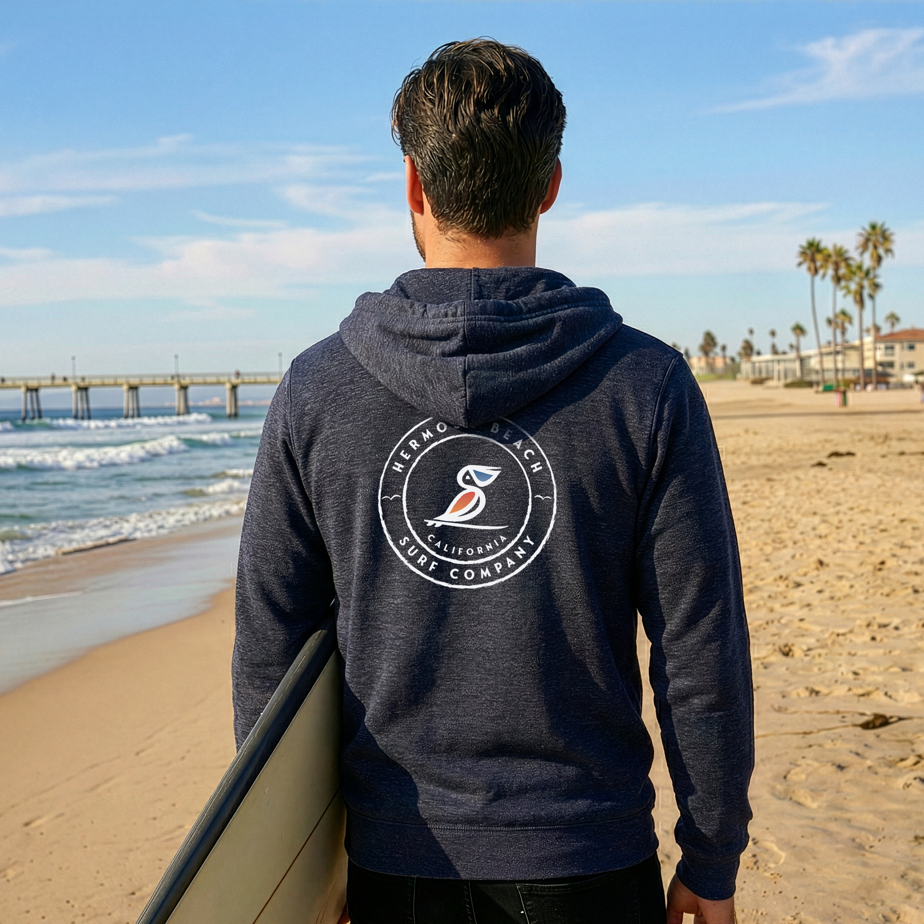 Person wearing a hoodie with a logo on the beach