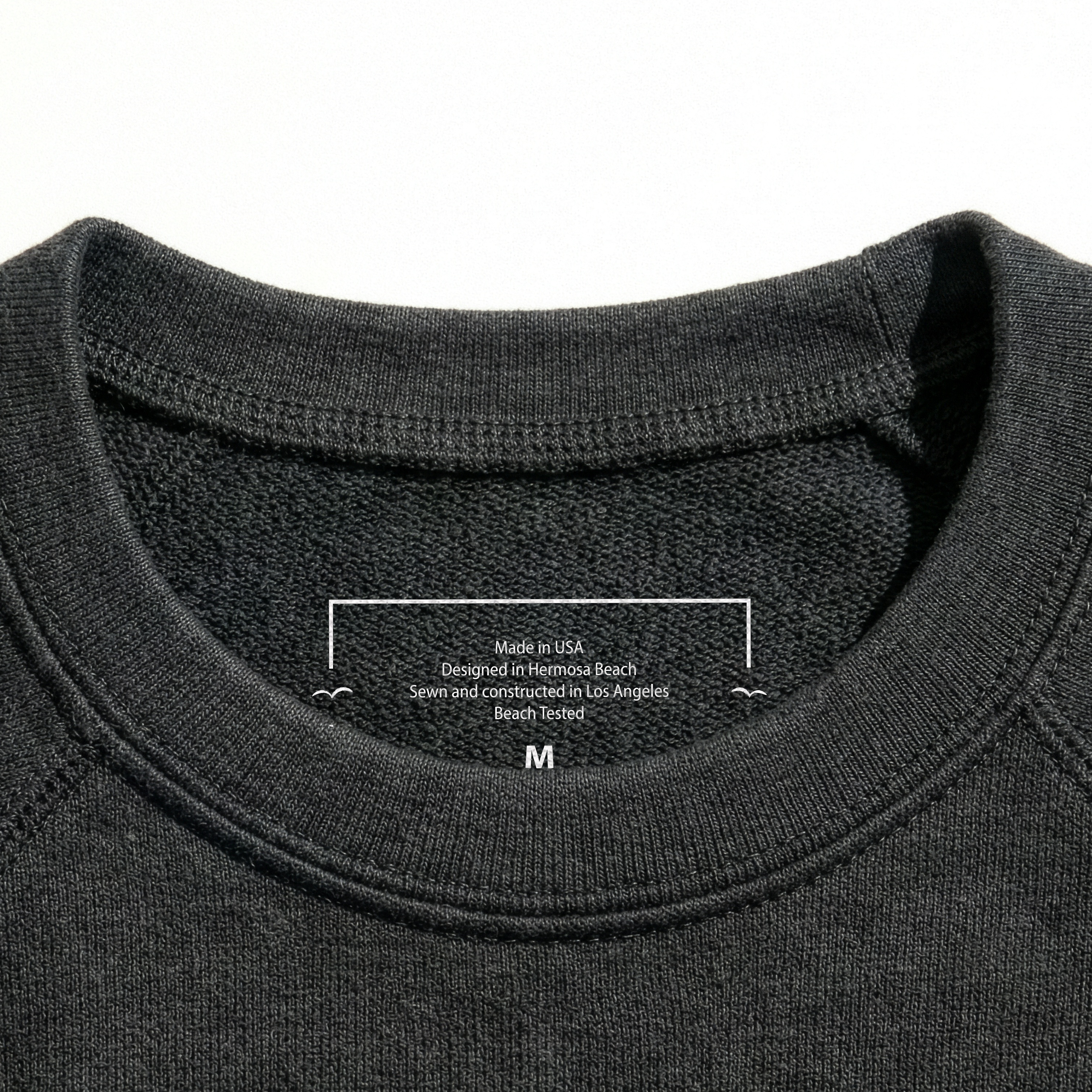 Close-up of a Grey sweatshirt collar with a label on a white background