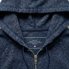 Close-up of a navy blue hoodie with text on the inside of the hood.